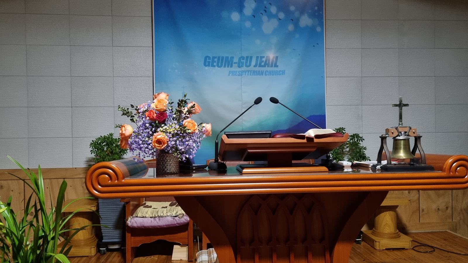 강대상 위 성경과 꽃꽂이, 옆에 놓인 나무 십자가